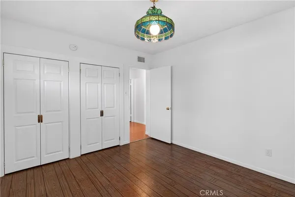 a view of a room with wooden floor and white walls