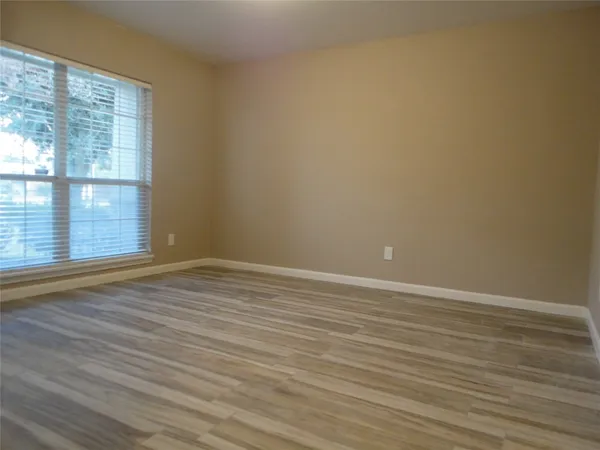 an empty room with windows and fan