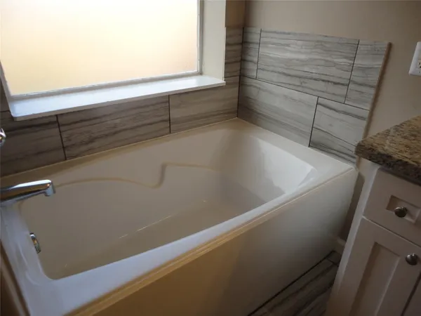 an empty room with a window and a chandelier fan