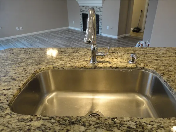 a kitchen with kitchen island granite countertop a sink stove and refrigerator