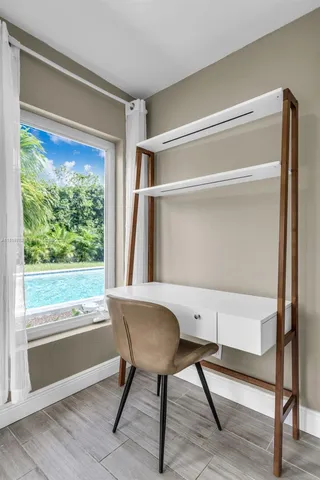 a view of a workspace with furniture and a window