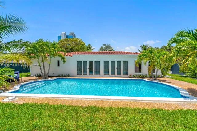 a view of a house with a swimming pool and a yard