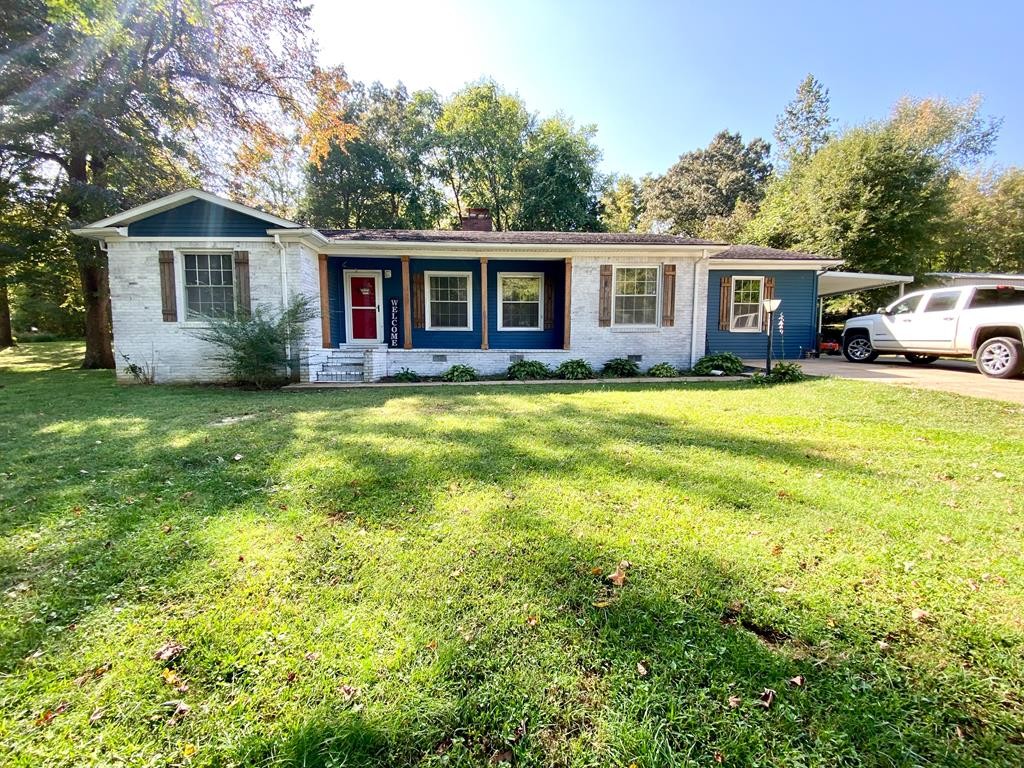173 Magnolia Street Camden, TN 38320 - Photo 1 of 22 a view of a yard in front of a house with a large tree
