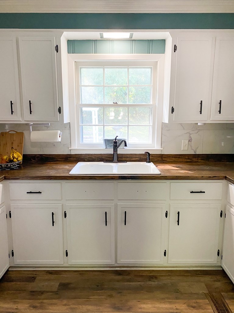 173 Magnolia Street Camden, TN 38320 - Photo 3 of 22 a kitchen with granite countertop white cabinets and a window