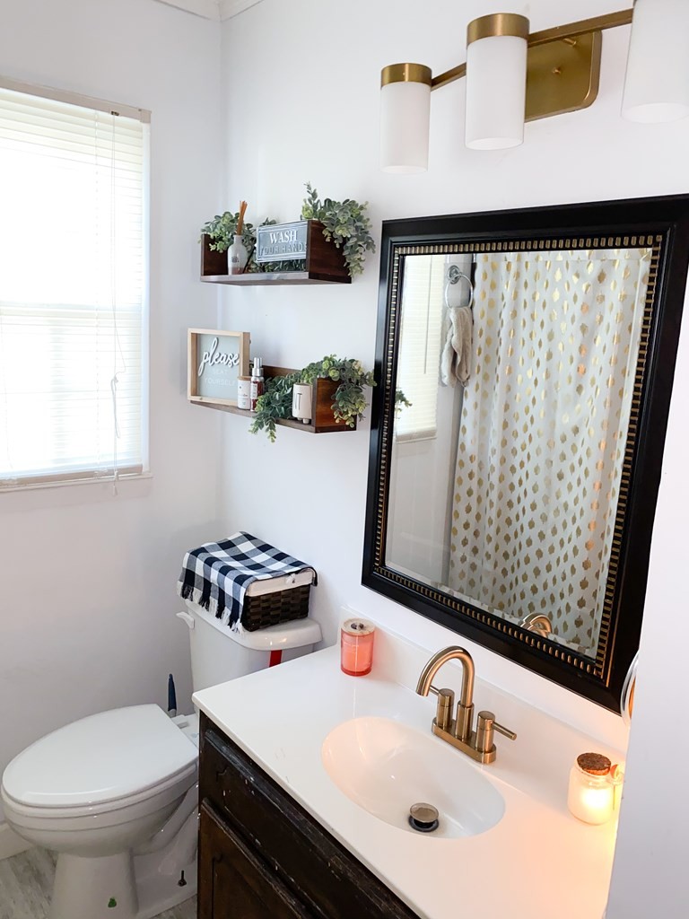 173 Magnolia Street Camden, TN 38320 - Photo 9 of 22 a bathroom with a sink toilet and a mirror