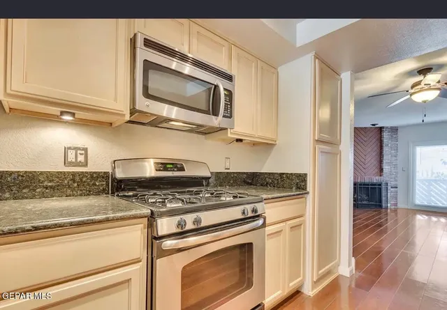 a kitchen with stainless steel appliances granite countertop a stove and a microwave