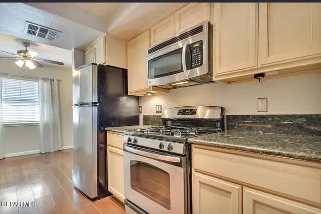 a kitchen with stainless steel appliances granite countertop a stove microwave and refrigerator