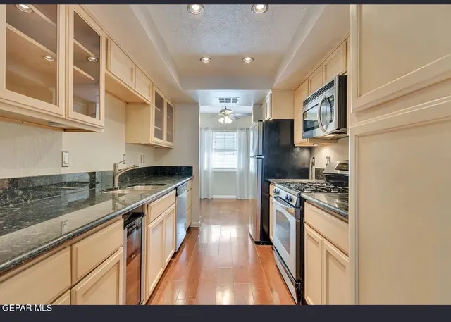 a kitchen with stainless steel appliances granite countertop a stove a sink and a refrigerator