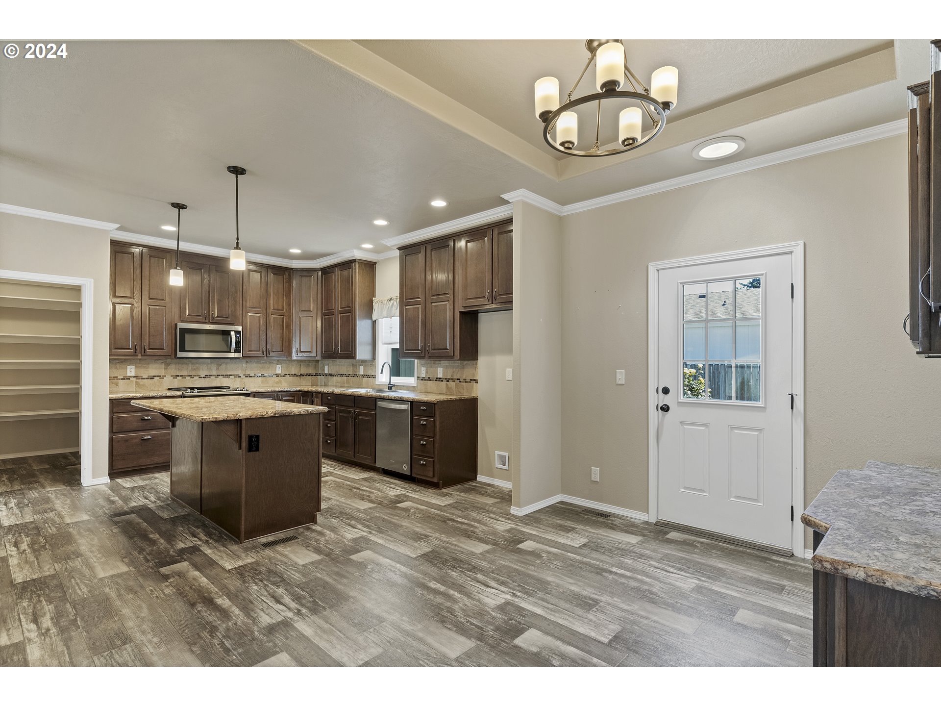 610 Vaughan Lane Lebanon, OR 97355 - Photo 10 of 35 a kitchen with stainless steel appliances kitchen island a refrigerator and a sink
