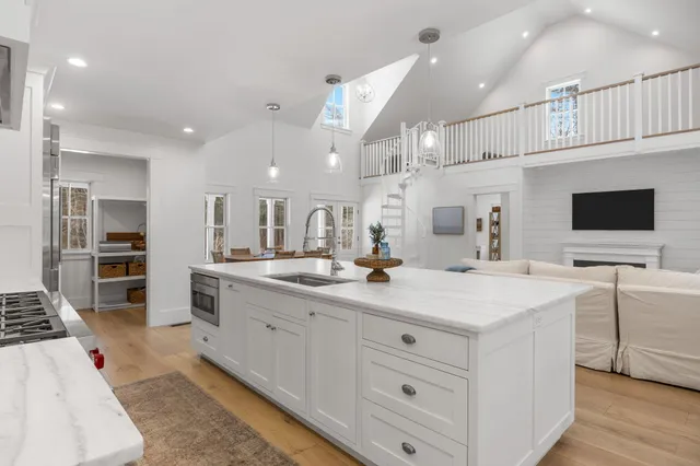 a kitchen with stainless steel appliances granite countertop a sink and cabinets with wooden floor