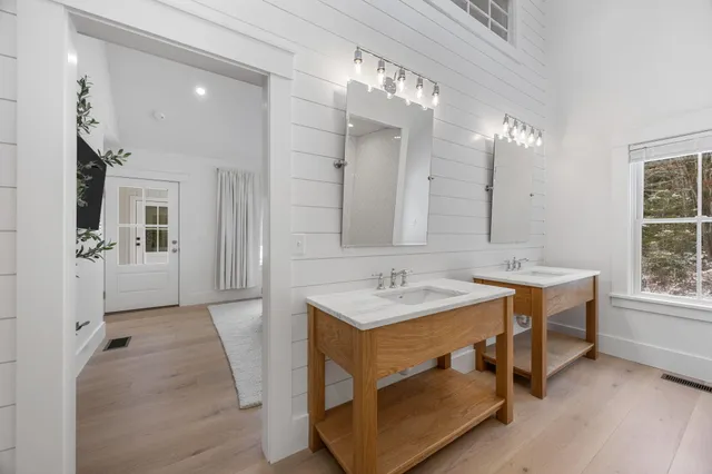 a bathroom with a granite countertop sink a mirror a vanity and a shower