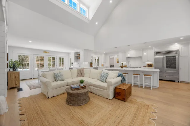 a living room with furniture white walls and kitchen view
