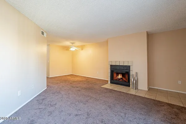 a view of an empty room with fire place and a fireplace