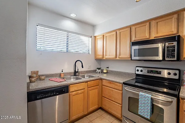 a kitchen with stainless steel appliances granite countertop a sink a stove a microwave and cabinets