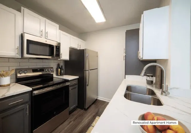 a kitchen with stainless steel appliances a stove a sink a refrigerator and cabinets