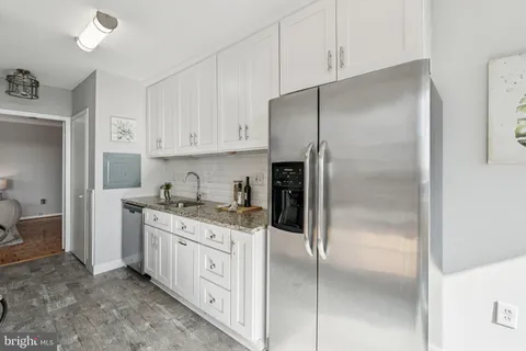 a kitchen with a refrigerator a sink and cabinets