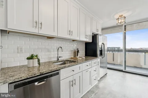 a kitchen with white cabinets and a sink