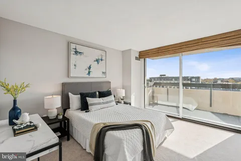 a bedroom with a bed and with large windows