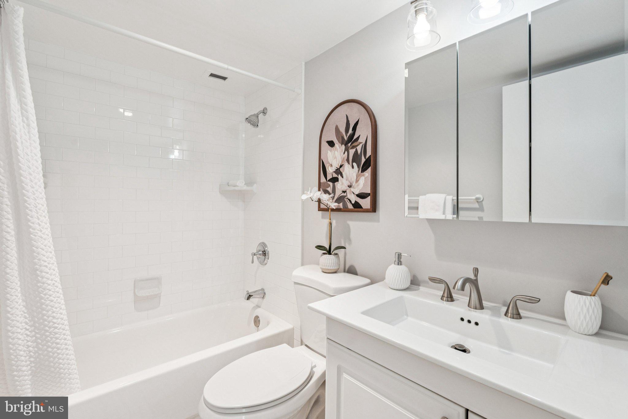 400 Madison Street, Unit 603 Alexandria, VA 22314 - Photo 27 of 46 a bathroom with a bathtub shower sink vanity and toilet