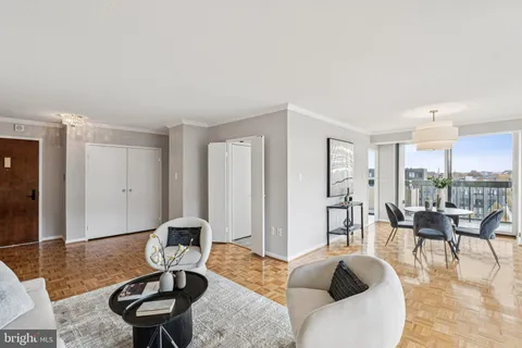 a living room with furniture a table and kitchen view