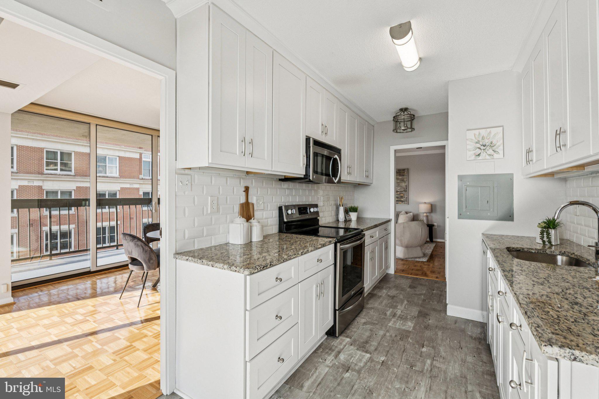 400 Madison Street, Unit 603 Alexandria, VA 22314 - Photo 9 of 46 a kitchen with stainless steel appliances granite countertop a stove top oven a sink a microwave and a refrigerator