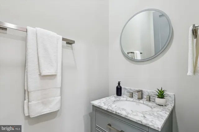a bathroom with a granite countertop sink and a mirror