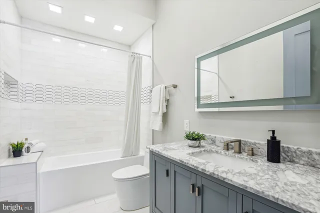 a bathroom with a granite countertop sink toilet and shower