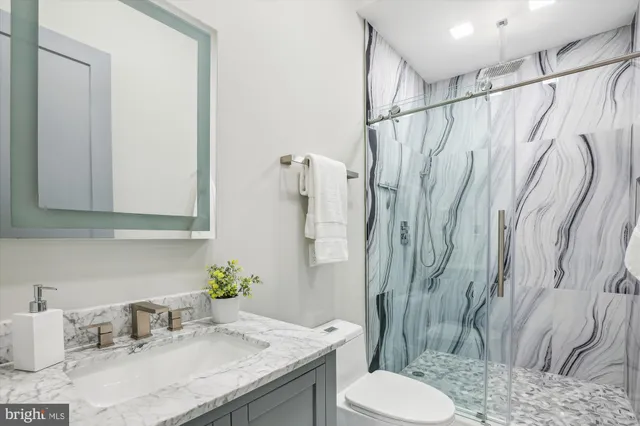a bathroom with a granite countertop sink toilet and shower