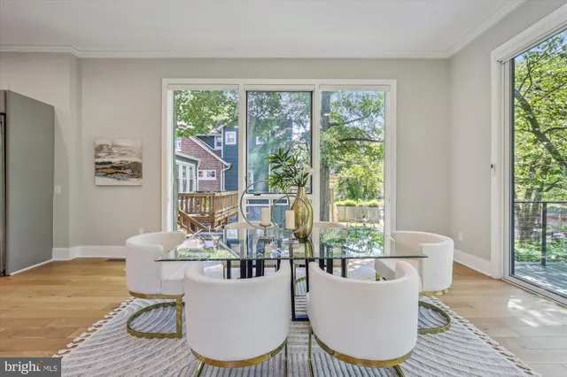 a living room with furniture a large window and dining table