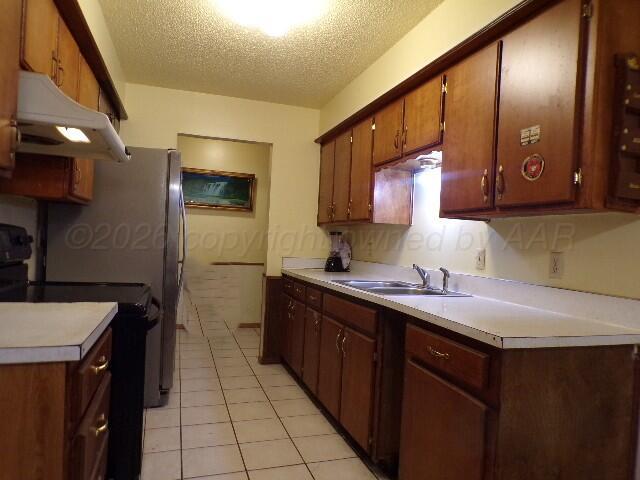 1620 Bluebell Street Amarillo, TX 79107 - Photo 10 of 28 a kitchen with a sink refrigerator and cabinets