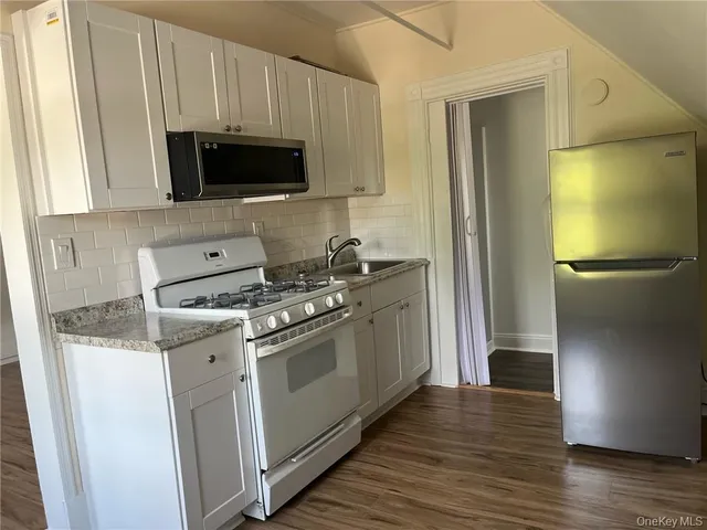 a kitchen with stainless steel appliances granite countertop a stove microwave and refrigerator