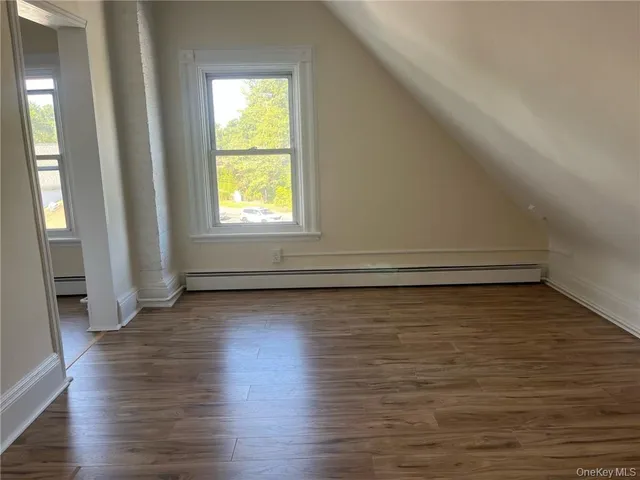 a view of a room with wooden floor and window