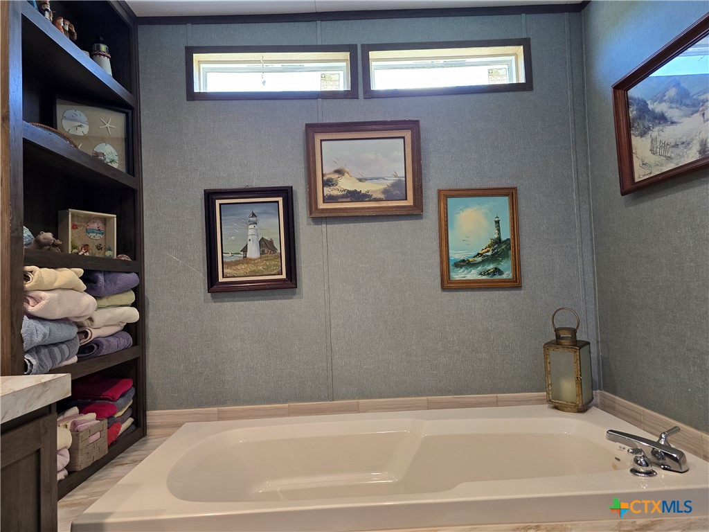 412 Coryell City Road Gatesville, TX 76528 - Photo 13 of 34 a bathroom with a bathtub and a bookshelf
