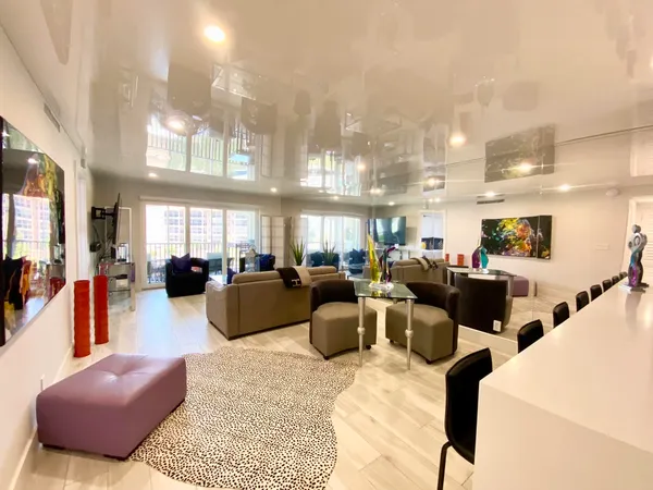 a living room with kitchen island furniture and a chandelier
