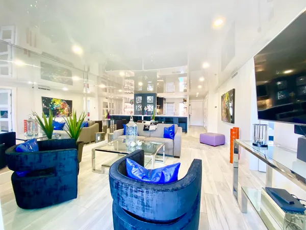 a living room with furniture kitchen view and a large window