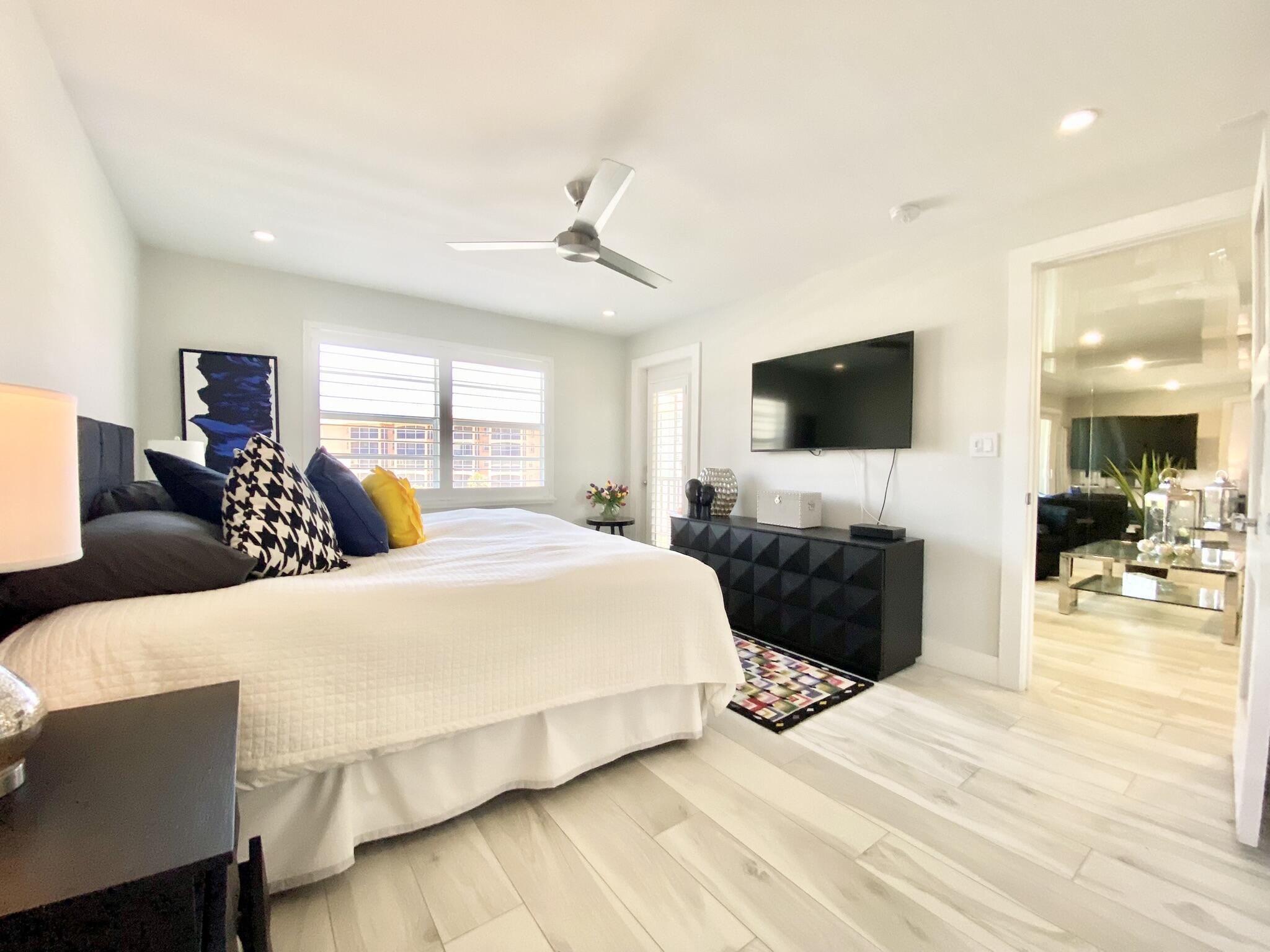 2871 North Ocean Boulevard, Unit M330 Boca Raton, FL 33431 - Photo 20 of 60 a bedroom with a large bed and a flat tv screen on dresser