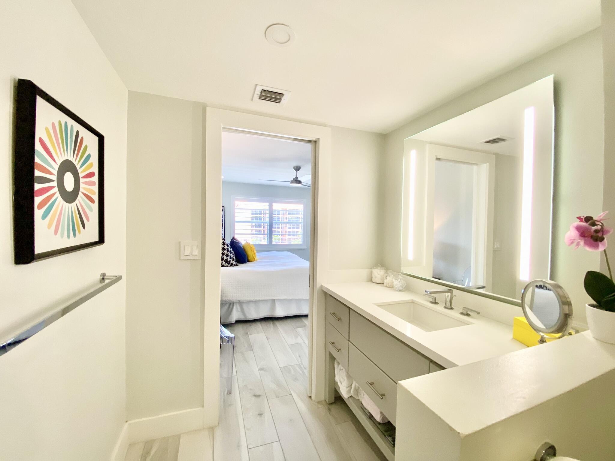 2871 North Ocean Boulevard, Unit M330 Boca Raton, FL 33431 - Photo 23 of 60 a en suite bathroom with a granite countertop tub sink and mirror