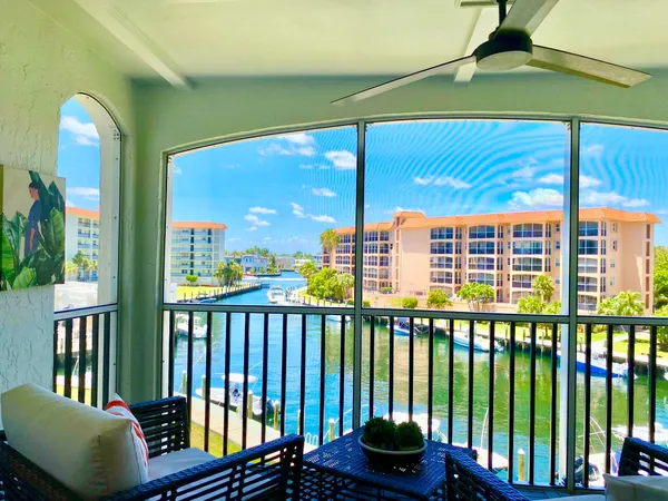 a view of fountain in front of a house with palm trees