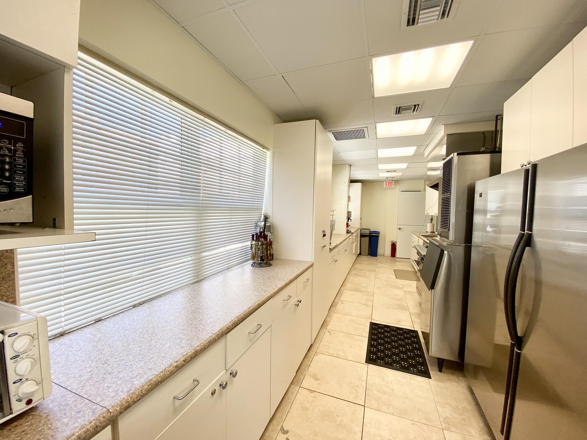 2871 North Ocean Boulevard, Unit M330 Boca Raton, FL 33431 - Photo 44 of 60 a large white kitchen with a large window