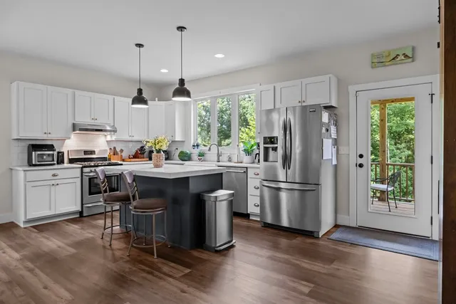 a kitchen with granite countertop white cabinets and appliances