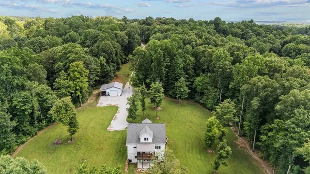an aerial view of a house with a yard swimming pool and outdoor seating