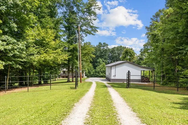 a house view with swimming pool and trees in the background