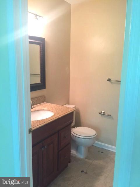 6527 Cypress Point Road Alexandria, VA 22312 - Photo 11 of 16 a bathroom with a granite countertop toilet and a sink