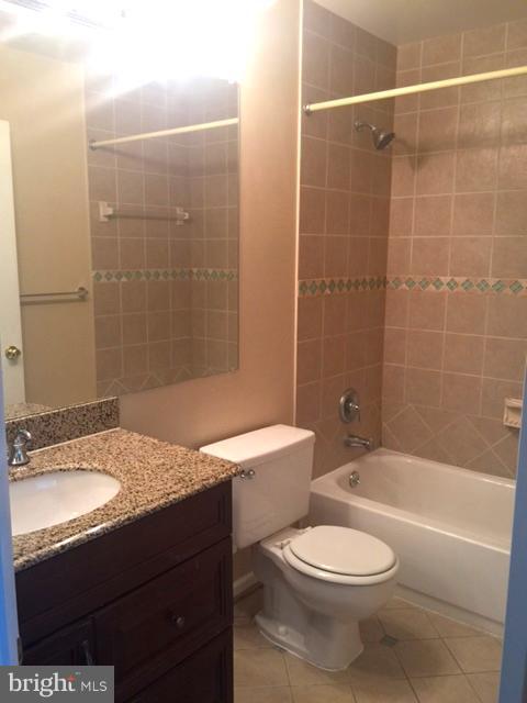 6527 Cypress Point Road Alexandria, VA 22312 - Photo 9 of 16 a bathroom with a granite countertop toilet a sink and bathtub