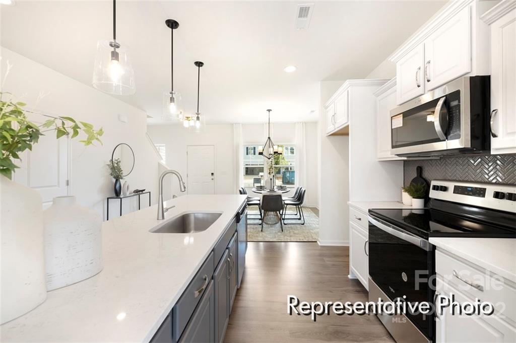 321 Copes Court, Unit 48 Kannapolis, NC 28081 - Photo 7 of 18 a kitchen with stainless steel appliances granite countertop a sink a stove and a wooden floors