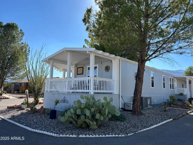 a view of a house with a yard and potted plants