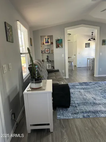 a kitchen with a stove a sink dishwasher white refrigerator a dining table and chairs with wooden floor