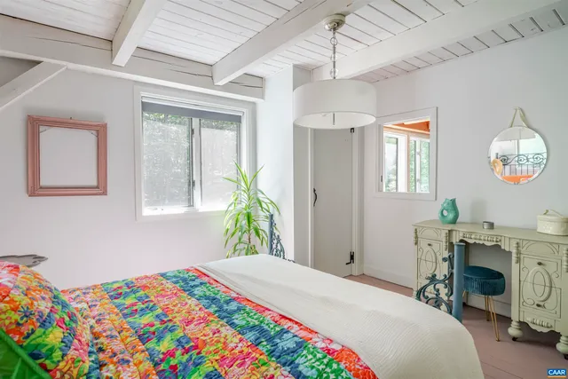 a bedroom with a bed a chandelier and a dresser