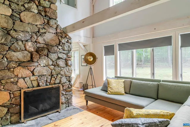 a living room with furniture a fireplace and a floor to ceiling window