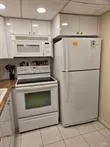 a white refrigerator freezer and a stove sitting inside of a kitchen